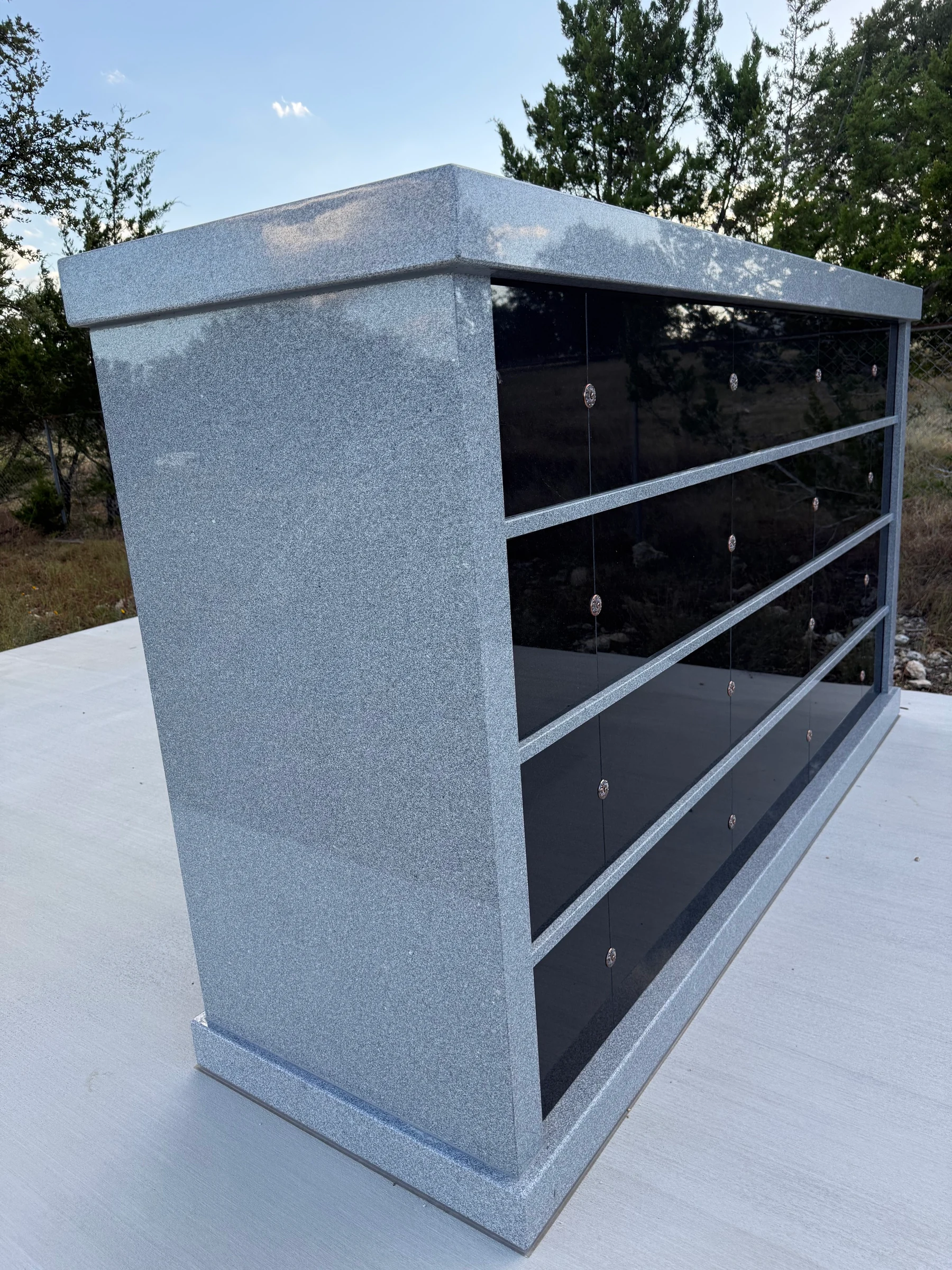 The solid gray granite side and polished black face of the installed columbarium.