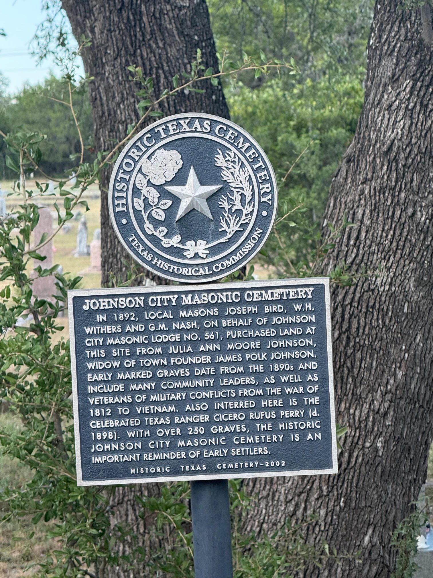 The Historic Texas Cemetery plaque under a live oak: the Texas Historical Commission seal above the marker text describing the 1892 purchase.